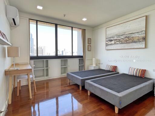 Bedroom with two beds, large window, and study desk