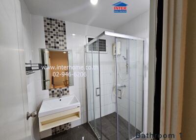 Modern bathroom with glass-enclosed shower and wall-mounted vanity