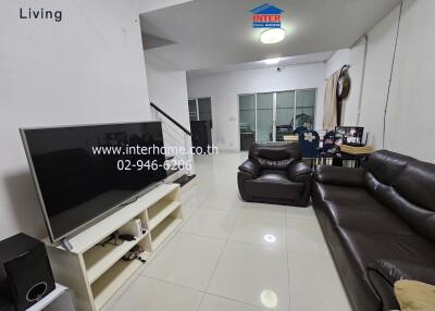 Living room with large TV and leather sofas