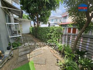 outdoor pathway with vegetation and neighboring houses