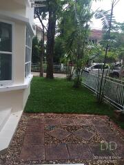 View of the front yard with green lawn and part of the building exterior