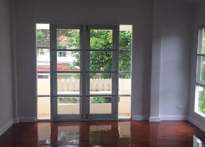 Bright and spacious living room with polished wooden floors and large windows