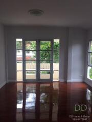 Bright and spacious living room with polished wooden floors and large windows