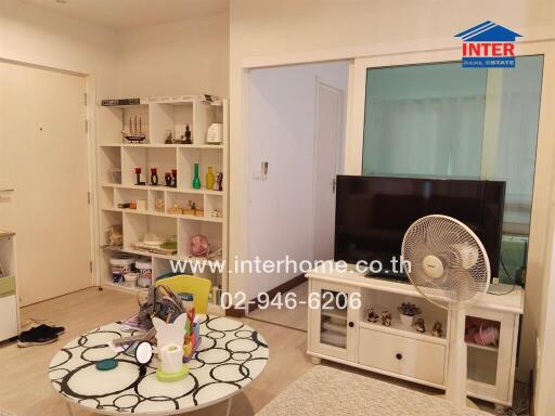 Cozy living room with bookshelf, TV, and sliding door