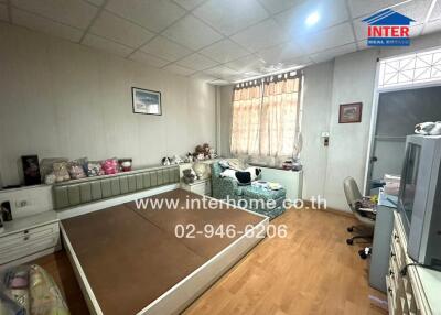 Well-lit bedroom with wooden flooring and built-in bed