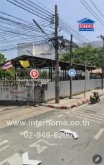 Street view of a property with power lines and a motorbike