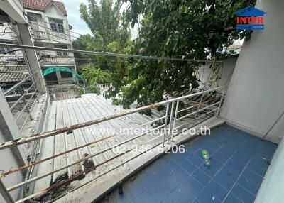 Balcony with blue floor tiles and overhead view of rooftops