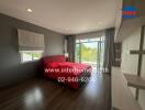 Modern bedroom with large window and red bedding