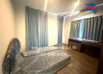 Bedroom with curtains, mattress and an air conditioner