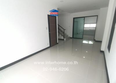 Modern living room featuring tiled flooring and a staircase