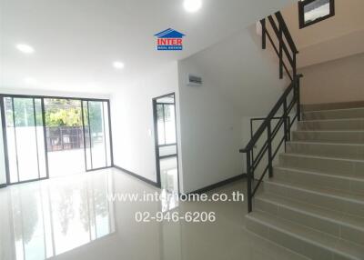 Main living space with staircase and large windows