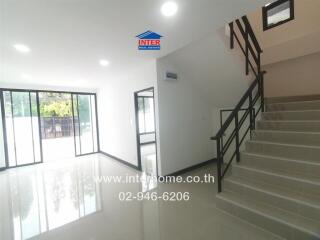 Main living space with staircase and large windows