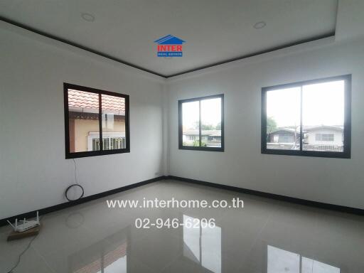 Spacious living room with large windows and glossy tiled floor