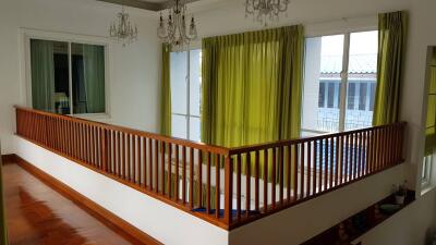 Upstairs hallway with green curtains and chandeliers