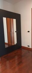 Bedroom with large mirror wardrobe and wooden floor