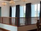 Spacious living room with wooden railings and large windows