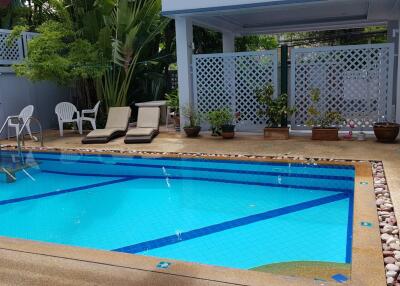Outdoor swimming pool with lounge chairs and plants