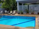 Outdoor swimming pool with lounge chairs and plants