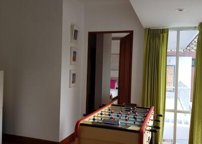 Room with foosball table and a glimpse of bedroom