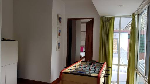 Room with foosball table and a glimpse of bedroom