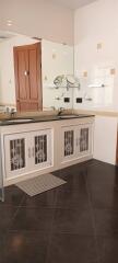 Modern bathroom with double sinks and wooden door