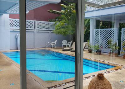 Outdoor pool area with seating and greenery