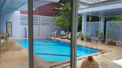 Outdoor pool area with seating and greenery