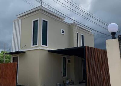 Modern two-story house exterior with large windows and cloudy sky