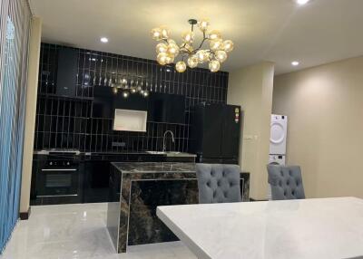Modern kitchen with island, chandelier, and dining area