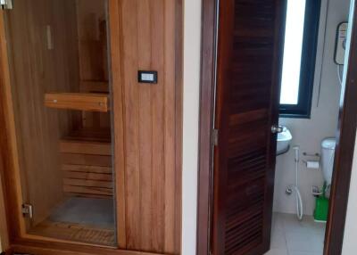 Modern bathroom with a wooden sauna and a toilet