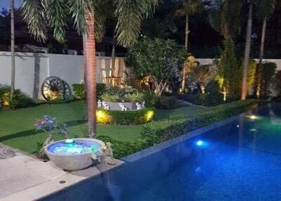 Beautifully landscaped backyard with a pool and garden at dusk