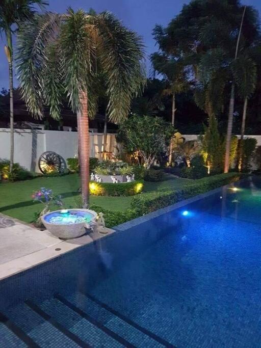 Beautifully landscaped backyard with a pool and garden at dusk