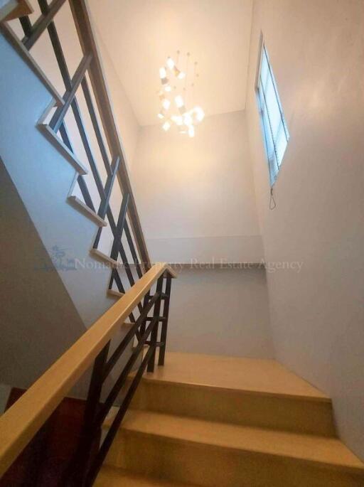 Indoor stairway with modern railing and a chandelier