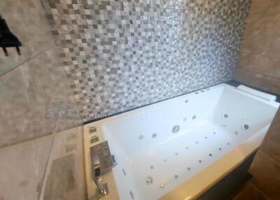 Luxurious bathtub with tiled wall