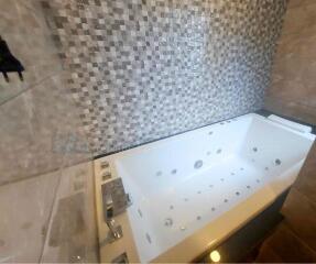 Luxurious bathtub with tiled wall