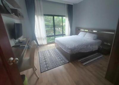 Bedroom with large window, double bed, desk and chair