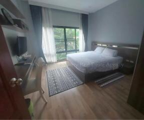 Bedroom with large window, double bed, desk and chair