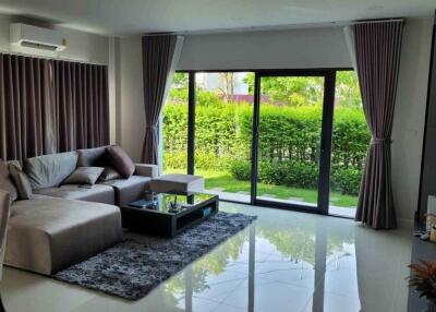 Modern living room with large glass doors and greenery