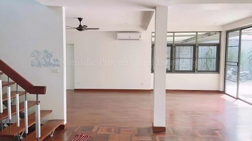 Spacious main living area with wooden floors and large windows