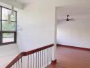 Spacious hallway with wooden flooring and large window