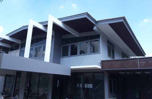 Modern two-story house exterior with large windows and unique architectural design