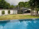 Outdoor pool with a lush garden and a covered parking area