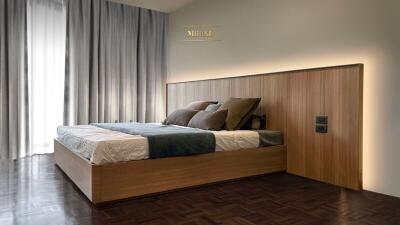 Modern bedroom with wooden bed frame and padded headboard