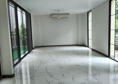 spacious living room with marble flooring and large windows
