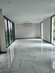 spacious living room with marble flooring and large windows