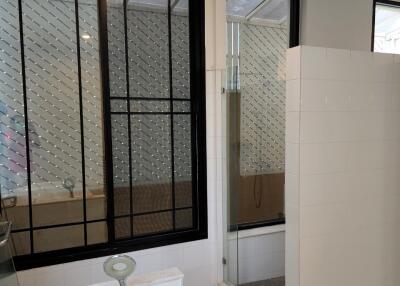 Bathroom with bathtub and glass-enclosed shower