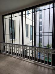 View through large window with black frames and ornamental balcony railing