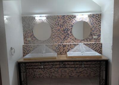 Bathroom with double vanities and mosaic tile wall