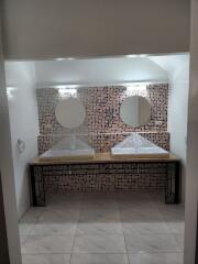 Bathroom with double vanities and mosaic tile wall