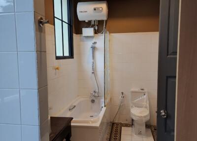 Bathroom with bathtub, toilet, and water heater